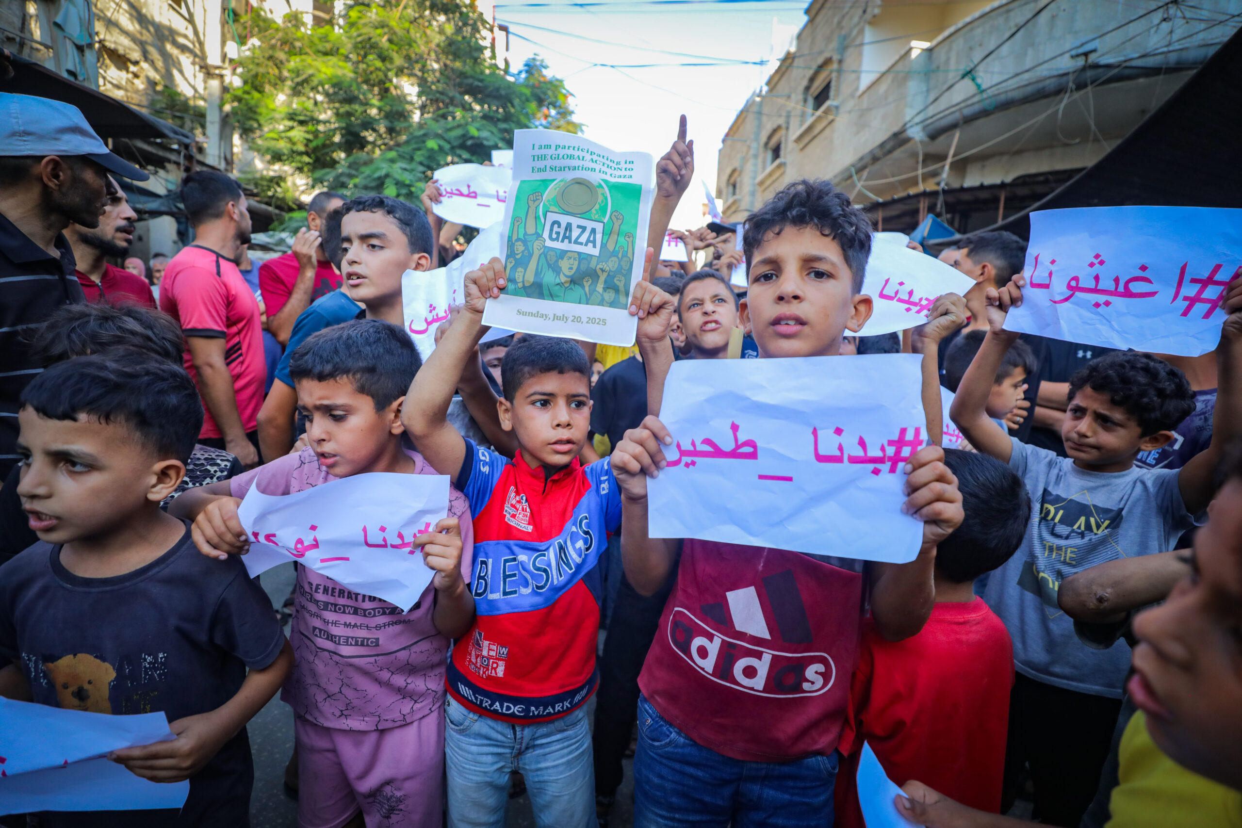 Children in Gaza hold up signs calling for an end to starvation
